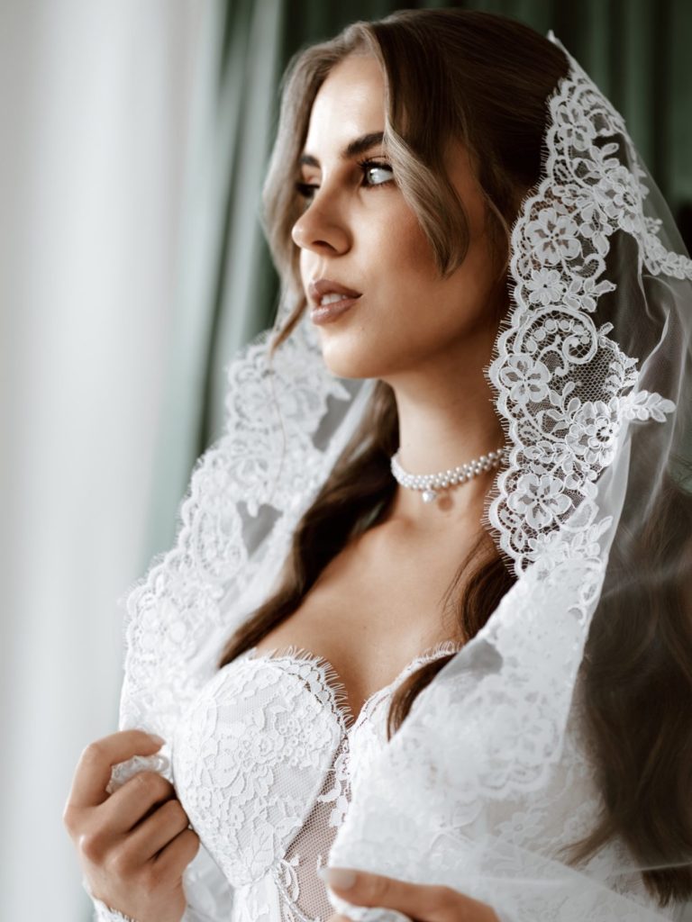 Paar in eleganter Hochzeitskleidung, umarmend am Wasser mit einer romantischen Atmosphäre.